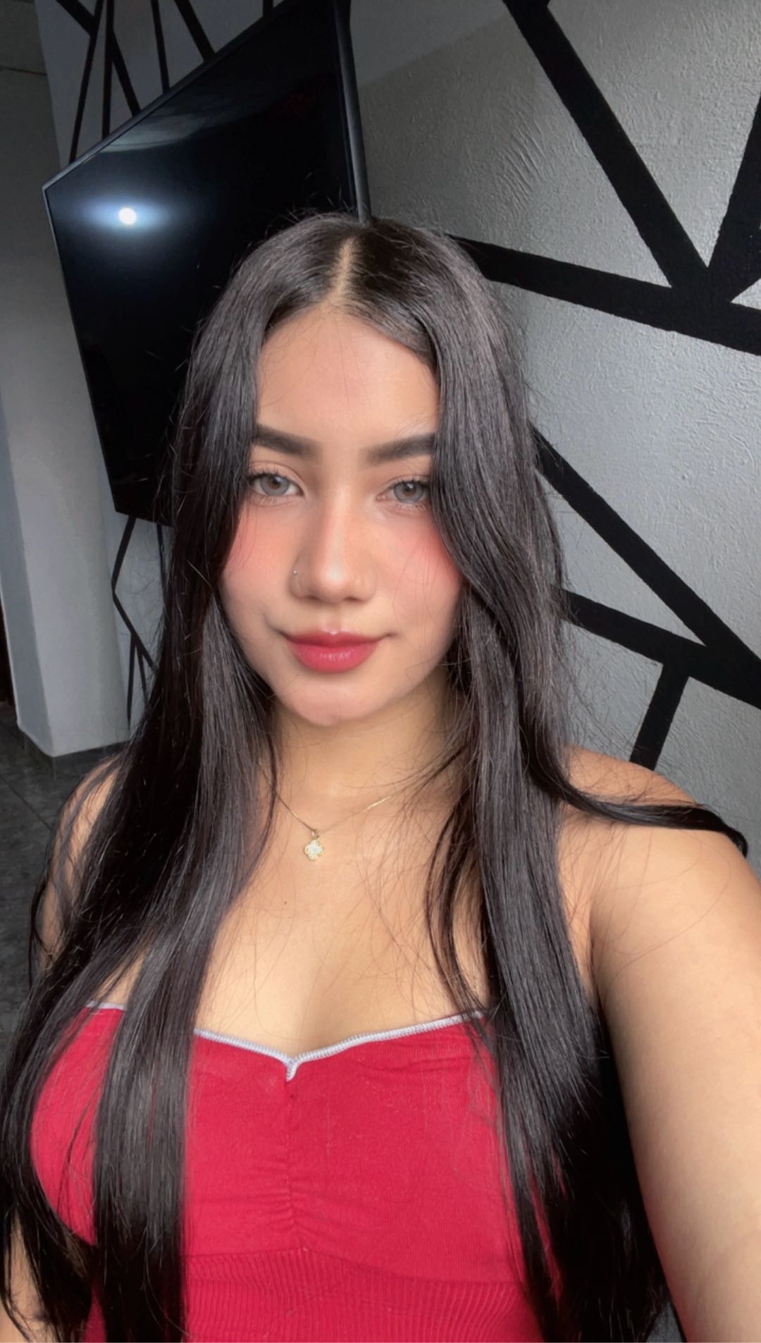 Woman in a red top looking into the camera, online girl preview