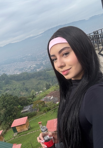 Adult woman outdoors with a mountain landscape behind her